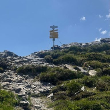 Richtung Wegweiser auf Berg bei strahlend blauem Himmel